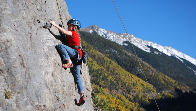 Child rock climbing with full safety gear in Taos, New Mexico